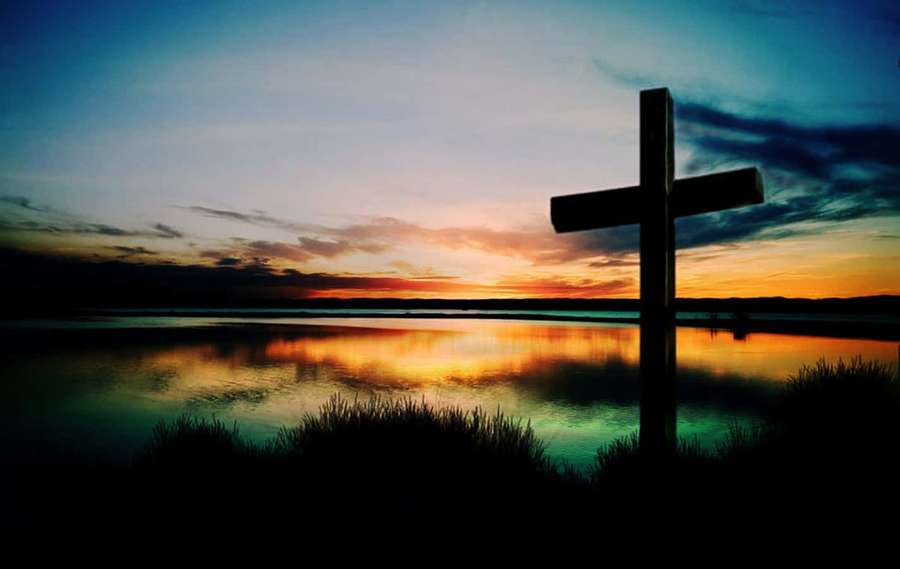 Silhouette of a cross at sunset over reflective water with dark grasses. — Cool Cross Wallpaper
