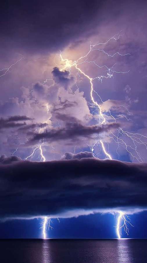 Poderosos raios iluminam um oceano tempestuoso sob um céu roxo escuro. — Cool Lightning Papéis de Parede