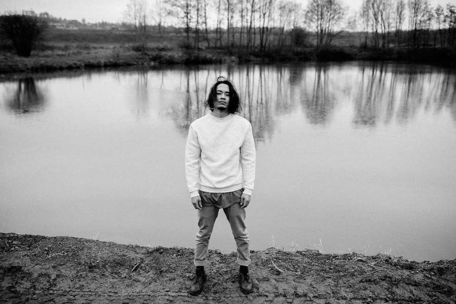 A person stands by a pond with tree reflections in black and white. — Cool Sad Background