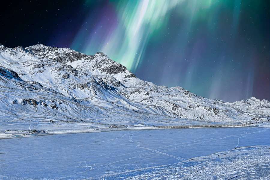 Norrsken lyser upp snötäckta berg och en frusen sjö på natten. — Cool Winter Bakgrundsbilder