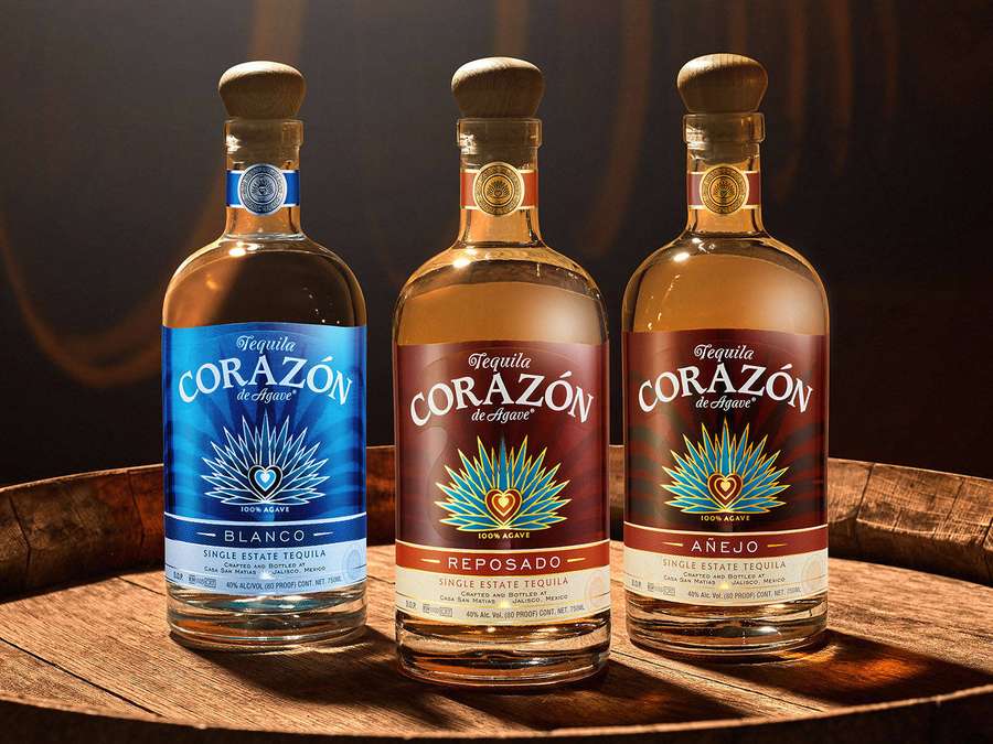 Tres botellas de tequila Corazón de Agave exhibidas sobre un barril de madera. — Corazon Fondos de pantalla