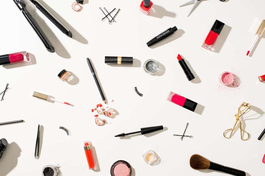 Collection of makeup products and tools on a white background. — Cosmetics Background