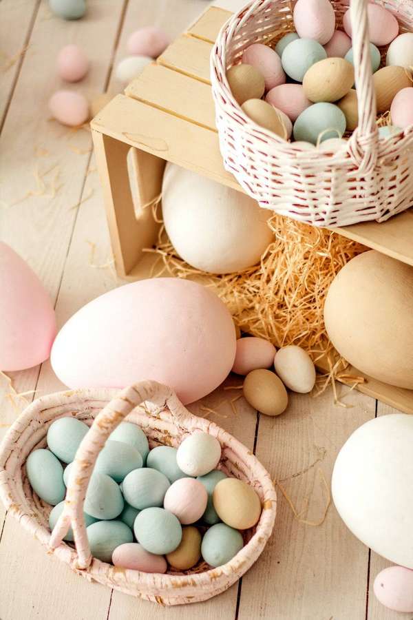 Ovos de Páscoa pastel em cestos e palha sobre tábuas de madeira. — Cozinhando Papéis de Parede