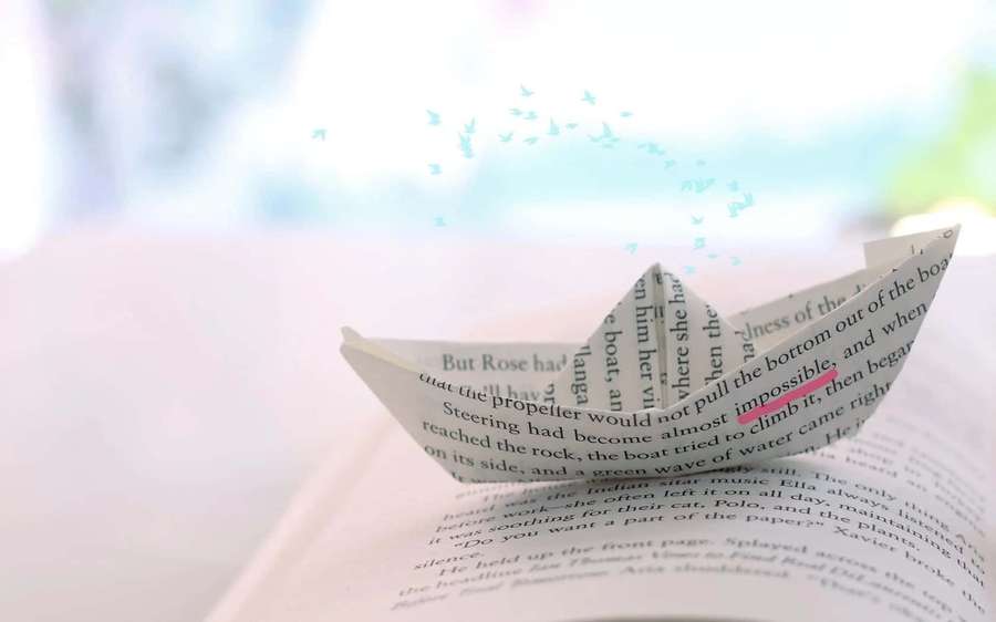 A paper boat made from a book page with birds flying above. — Creative Background