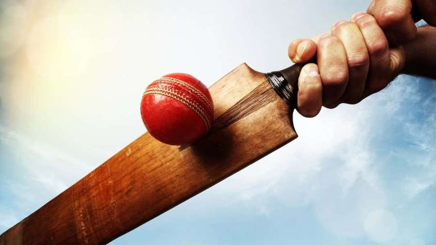 Hand holding cricket bat about to hit red cricket ball against blue sky. — Cricket Background