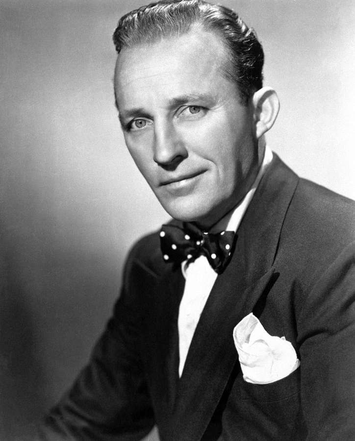 A man in a suit and bow tie smiling in a studio portrait. — Crosby Wallpaper