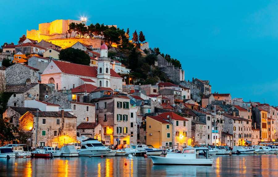 Coastal town at dusk with glowing lights and boats in harbor — Crotia Wallpaper