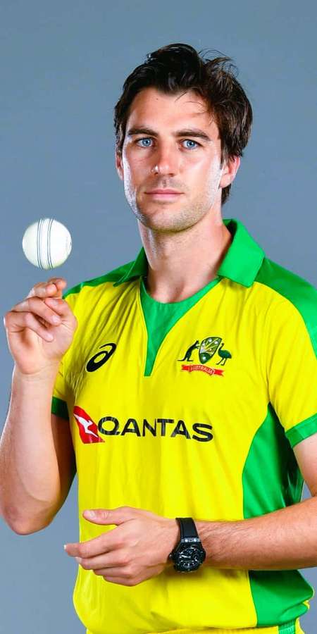 Cricket player in yellow and green uniform holding a cricket ball. — Cummins Picture