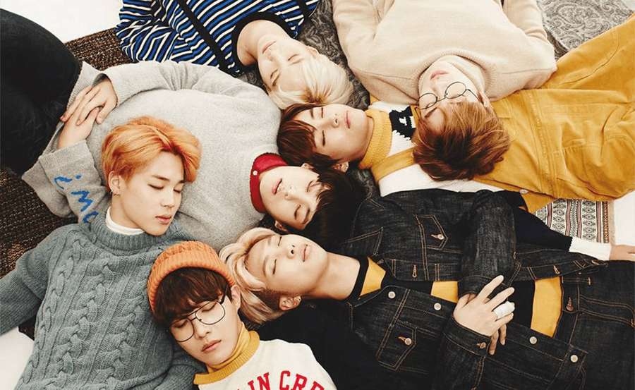 Seven young men in casual clothes lying in a circle on a rug, eyes closed. — Cute Bts Wallpaper