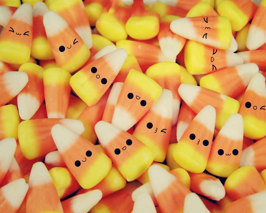 Candy corn with drawn faces smiling and winking. — Cute Candy Wallpaper