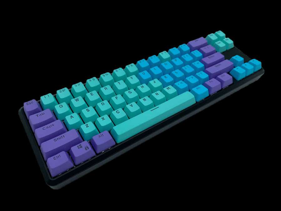 A colorful mechanical keyboard with teal and purple keys on a black background. — Cute Keyboard Background