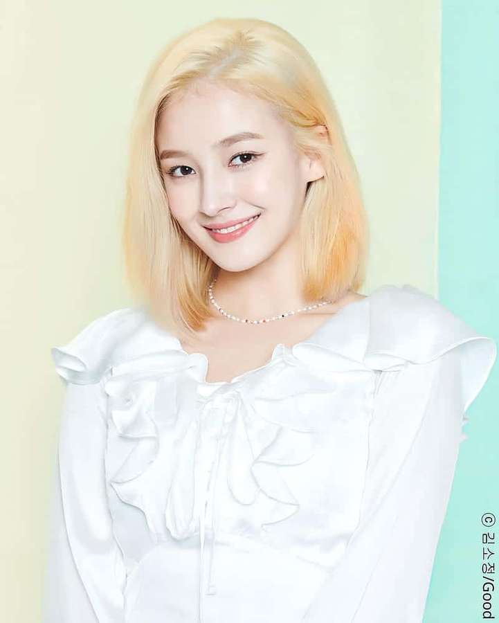 Young woman with blonde hair smiling in a white ruffled blouse. — Cute Korean Wallpaper