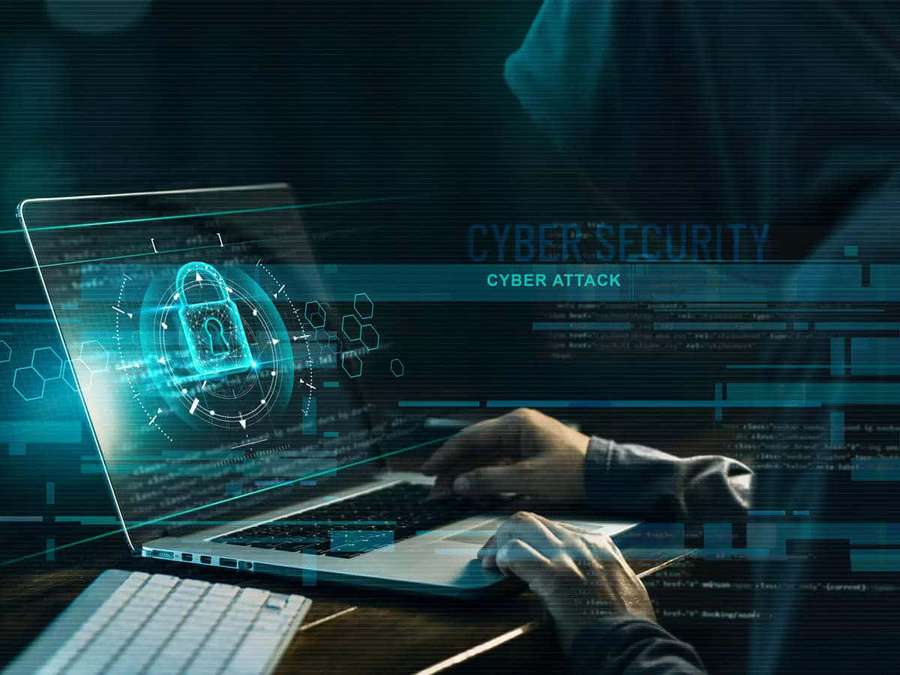 Person in hoodie typing on laptop with glowing cyber security holograms and code overlay. — Cybersecurity Background