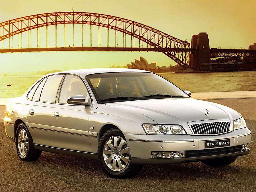 Hopeinen Statesman-auto pysäköitynä lähellä Sydney Harbour Bridge -siltaa ja oopperataloa auringonlaskun aikaan. — Daewoo Taustakuvat