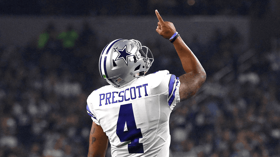 Football quarterback Dak Prescott celebrates with raised finger in stadium at night. — Dak Prescott Background