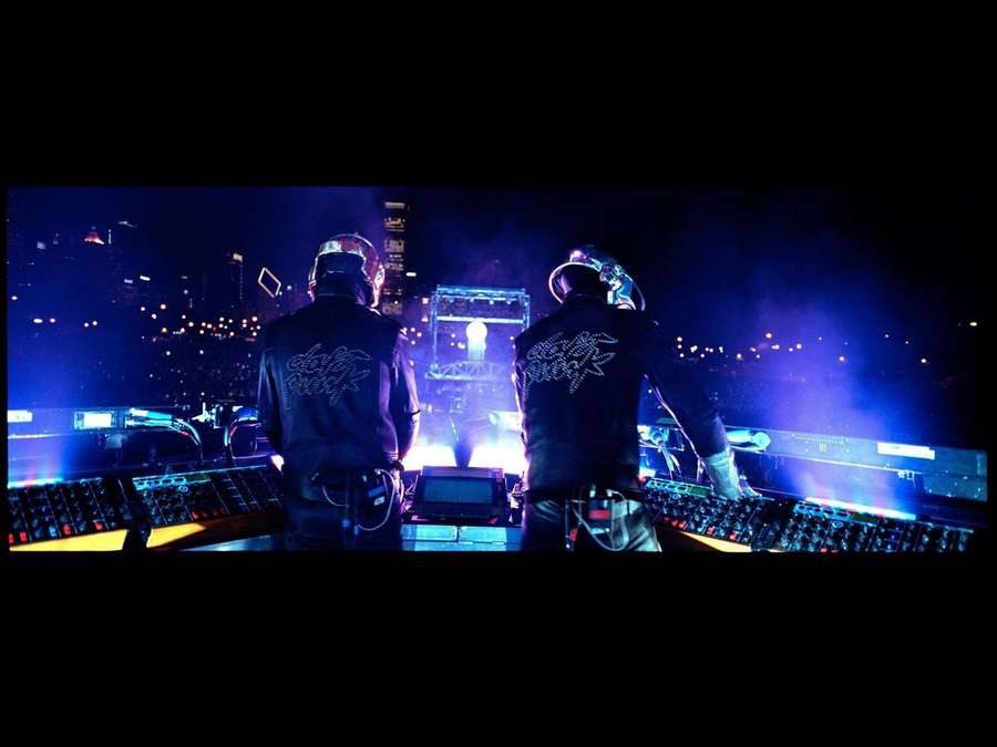 Zwei DJs in Helmen treten bei einem nächtlichen Konzert mit leuchtenden Bühnenlichtern auf. — Dämlich Wallpaper