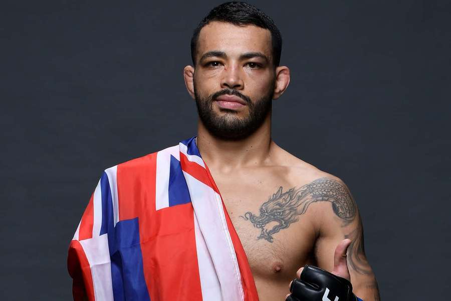 Muscular fighter draped in Union Jack flag with dragon tattoo holding gloves. — Dan Ige Wallpaper