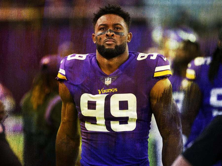 Minnesota Vikings fotballspiller iført nummer 99 i lilla trøye på banen om natten. — Danielle Hunter Bakgrunner
