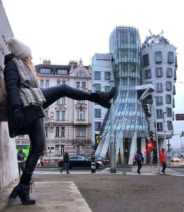 Kvinde poserer med højt spark nær Dansende Hus i Prags centrum. — Dansende Hus Wallpapers