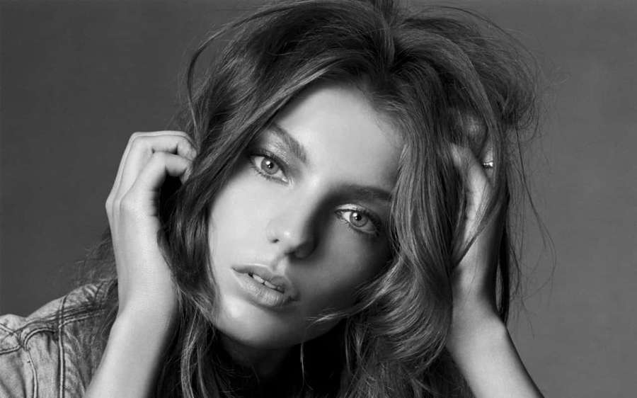 Nainen, jolla on takkuiset hiukset, katsoo suoraan kameraan mustavalkoisessa studiomuotokuvassa. — Daria werbowy Taustakuvat