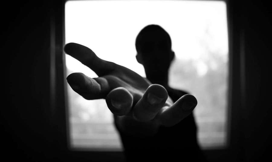 A person's silhouette reaches through a window with an outstretched hand. — Dark Hand Wallpaper