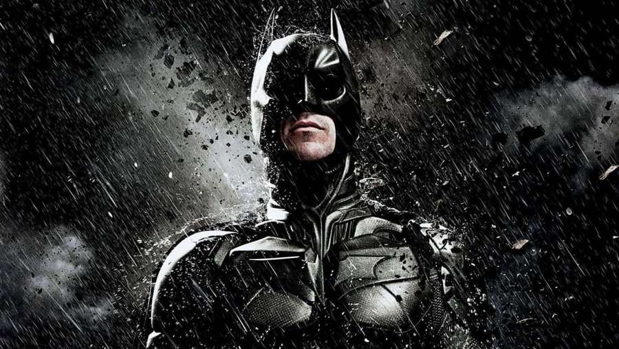 Batman in a rainstorm with flying debris around him. — Dark Knight HD Wallpaper