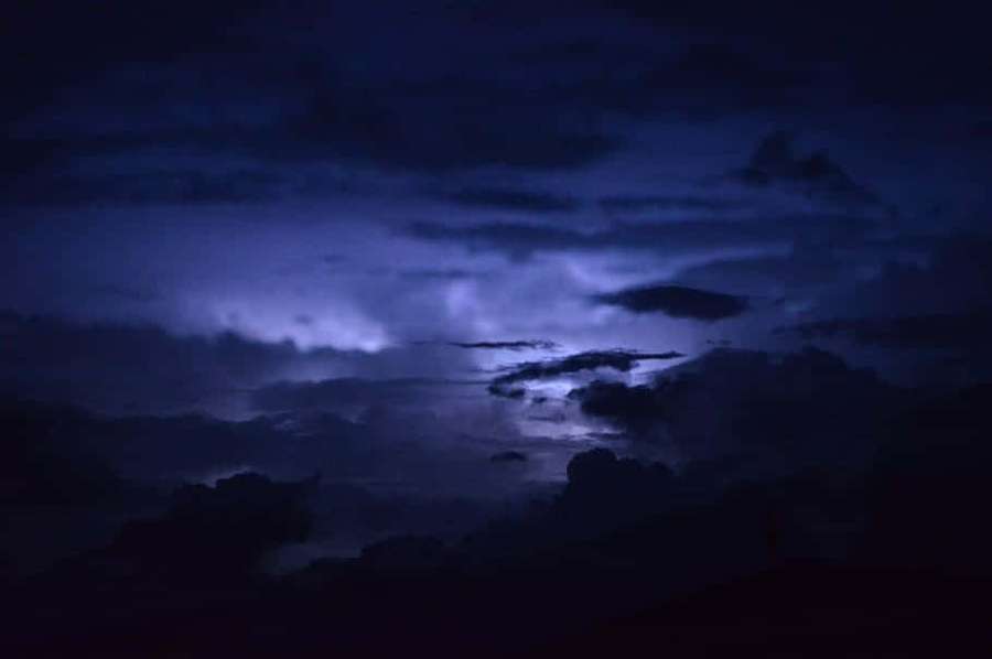Dunkle Sturmwolken, erleuchtet von einem violetten Blitz in der Nacht. — Dark Moody Wallpaper