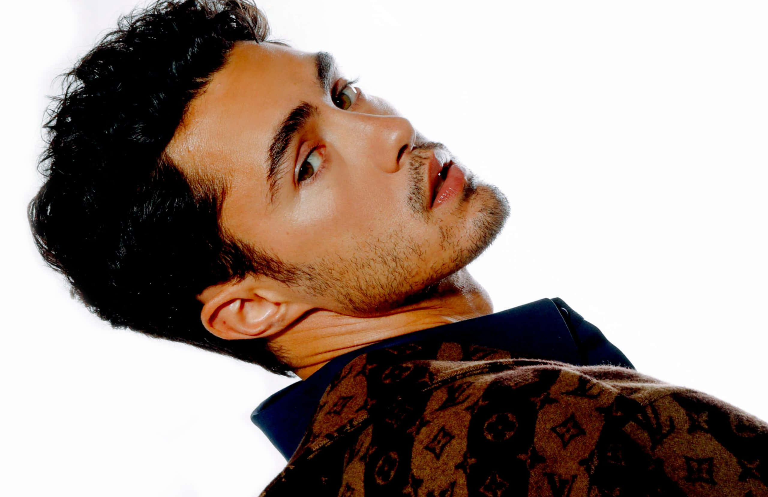 Man with dark hair and beard looking up wearing patterned jacket — Darren Picture