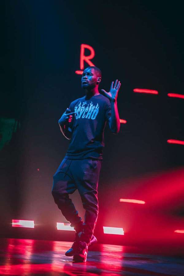 Male performer on stage under red and blue lights wearing a 'PSYCHO' shirt. — Dave Wallpaper