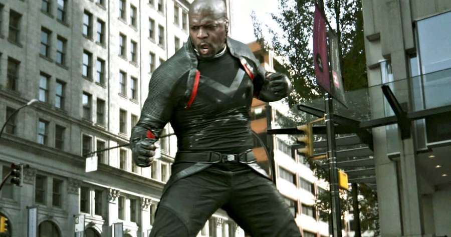 A man in a black and red tactical suit runs through a city street. — Deadpool Bedlam Wallpaper