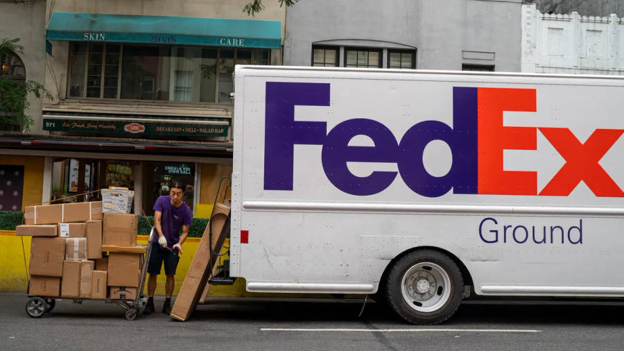 FedEx-leveransförare skjuter vagn med paket bredvid lastbil på stadsgata. — Leverans bakgrund Bakgrundsbilder