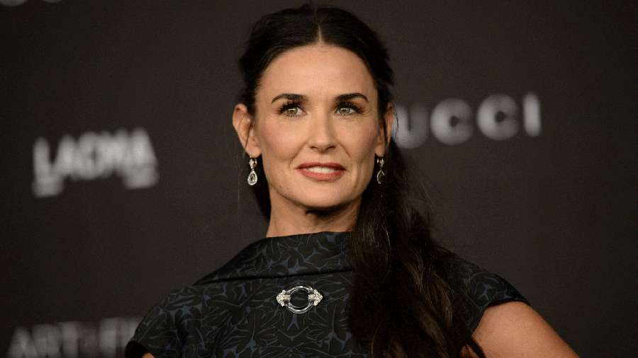 Demi Moore en un evento de moda de lujo luciendo un vestido negro con accesorios plateados. — Demi moore Fondos de pantalla