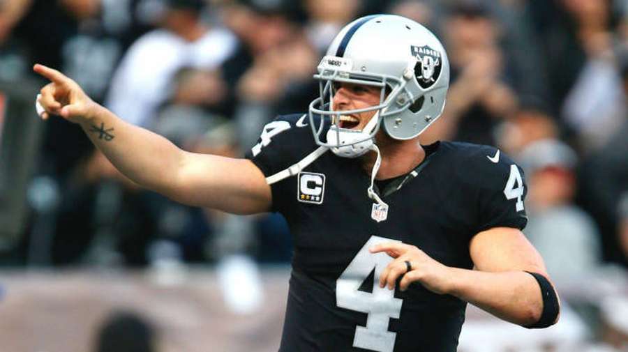 American football quarterback in Raiders uniform pointing during game. — Derek Carr Wallpaper