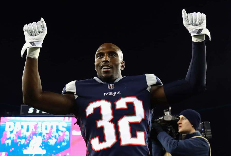 Jalkapalloilija numero 32 juhlii voittoa nyrkit koholla yöllä. — Devin Mccourty Taustakuvat