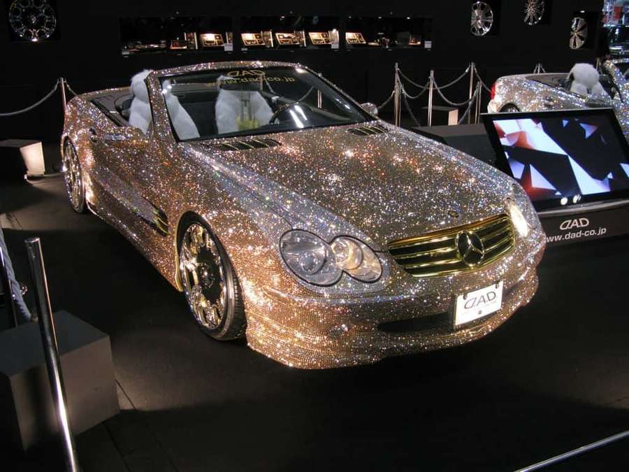 A diamond-encrusted Mercedes-Benz convertible on display in a dark showroom. — Diamond Car Wallpaper