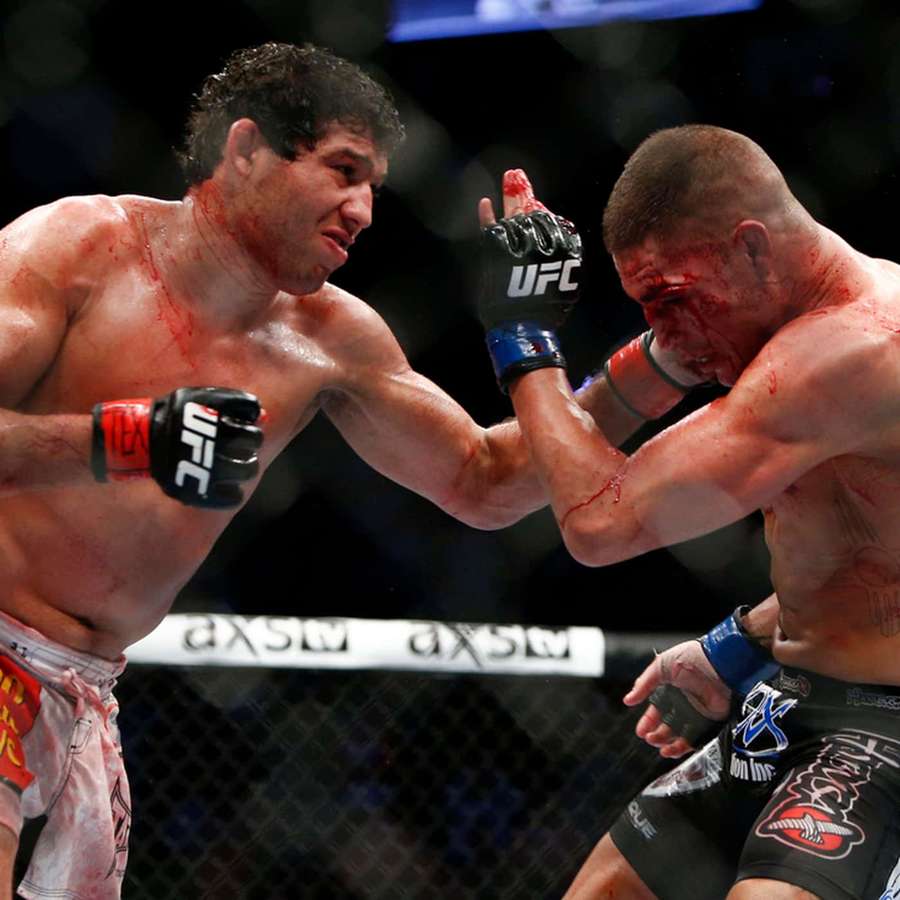 Zwei Kämpfer tauschen Schläge in einem blutigen MMA-Käfigkampf aus. — Diego Sanchez Bilder