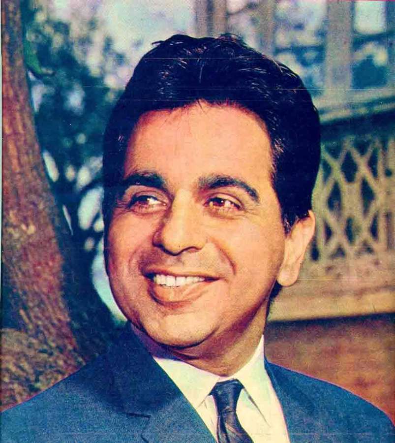 A smiling man in a blue suit and tie outdoors. — Dilip Wallpaper
