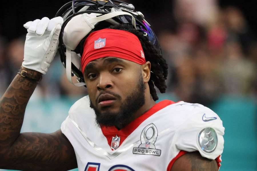 NFL player in Pro Bowl uniform lifting helmet with serious expression. — Diontae Johnson Wallpaper