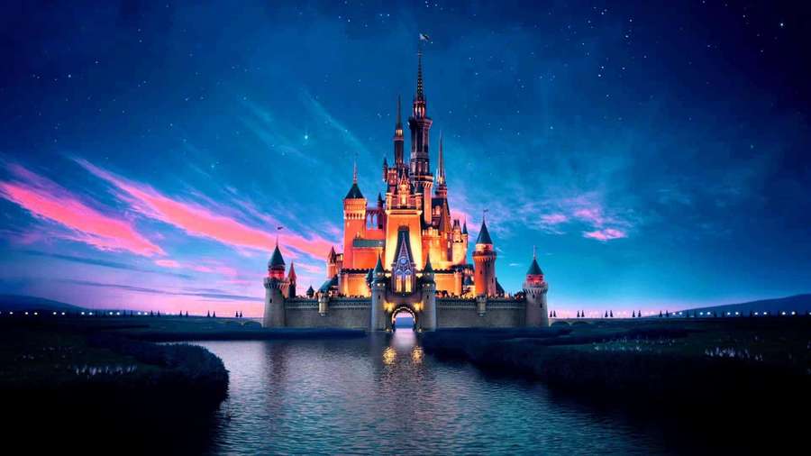 Disney castle lit at night with starry sky and water reflection — Disney Castle Background