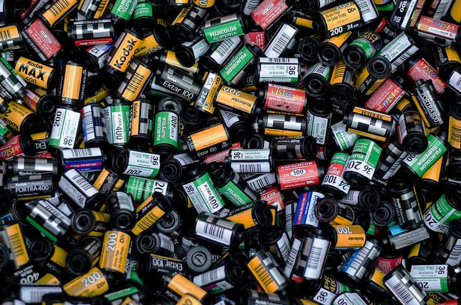 A pile of assorted vintage film rolls with colorful labels. — Disposable Wallpaper