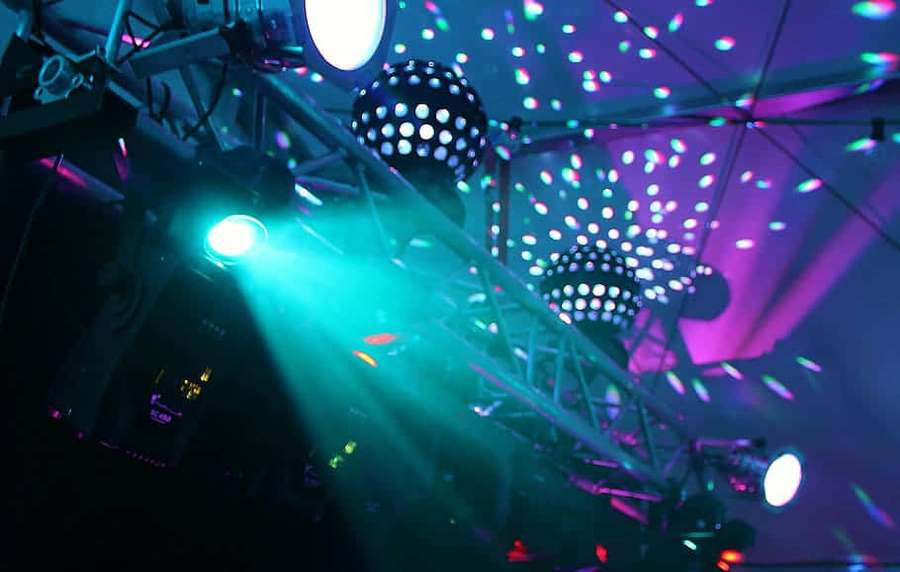 Colorful disco lights and mirrorballs illuminate a dark nightclub ceiling. — Dj Lighting Wallpaper
