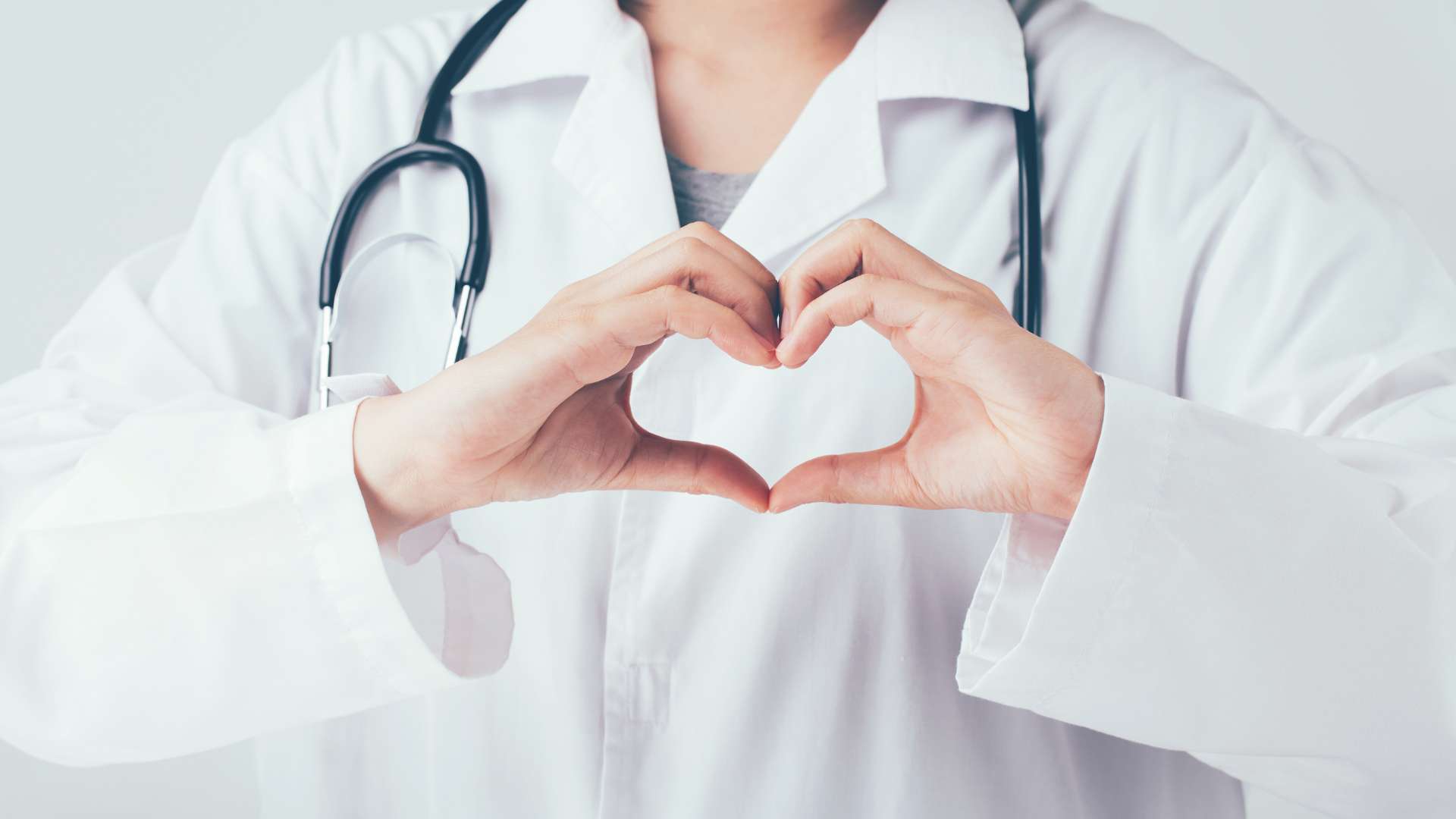 Doctor forming a heart shape with hands while wearing a stethoscope. — Doctor Background