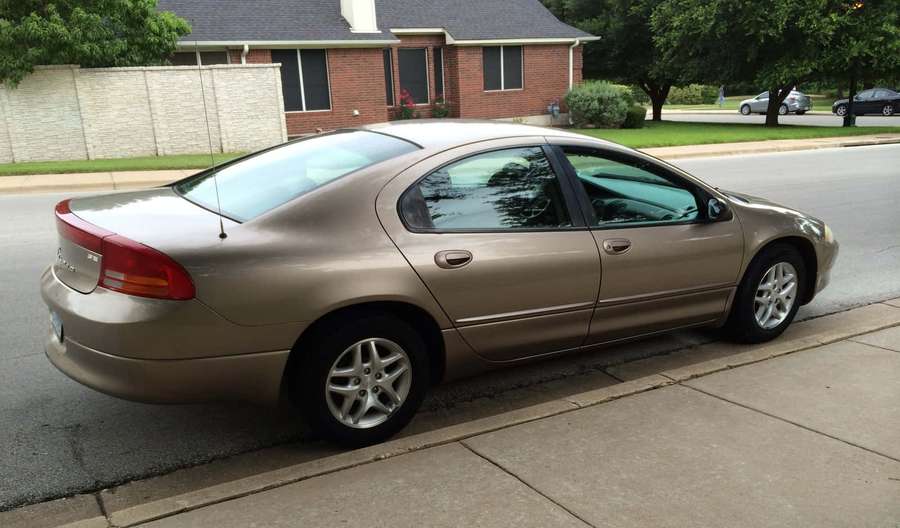 Gold sedan parked on residential street beside sidewalk. — Dodge Intrepid Wallpaper