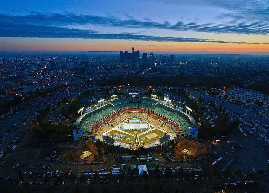 Baseball stadium lit at dusk with city lights in the background. — Dodger Stadium Wallpaper