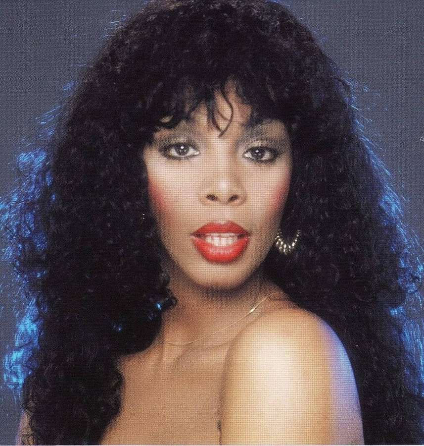 A woman with curly black hair and red lips in a studio portrait. — Donna Summer Wallpaper