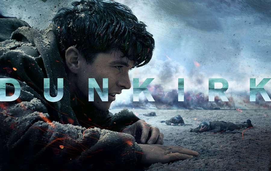 Soldier crawling on beach during wartime explosion — Dunkirk Wallpaper
