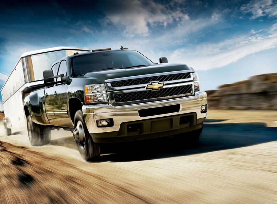 Black Chevrolet pickup truck speeding on a dirt road with motion blur. — Duramax Wallpaper