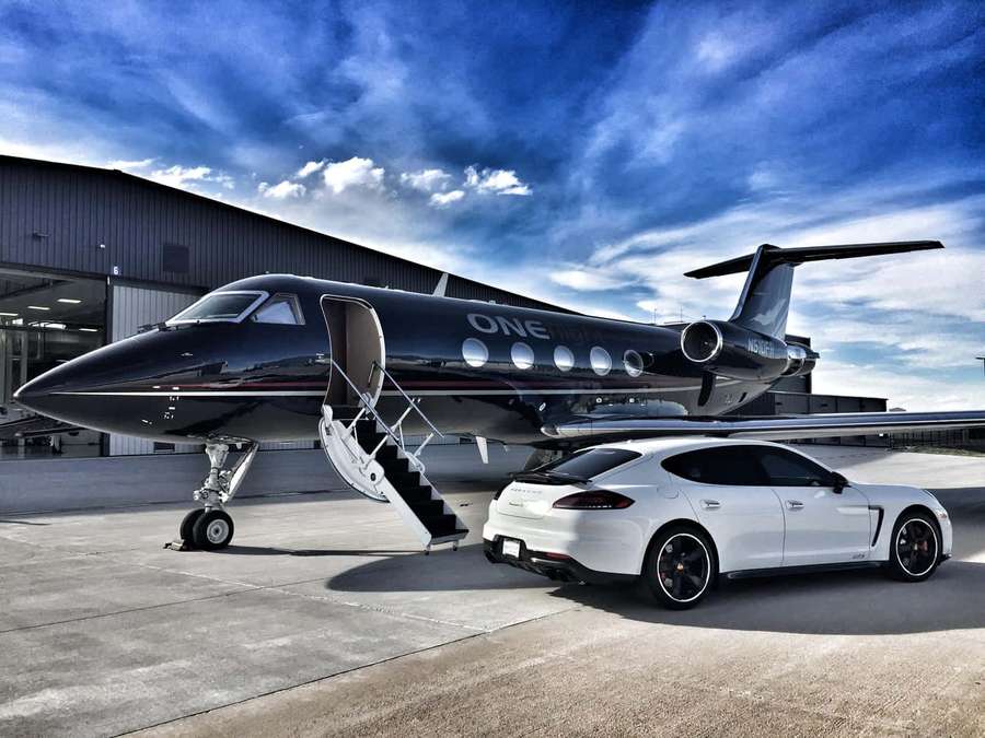 Schwarzer Privatjet und weißer Sportwagen zusammen auf dem Rollfeld. — Düsen Wallpaper