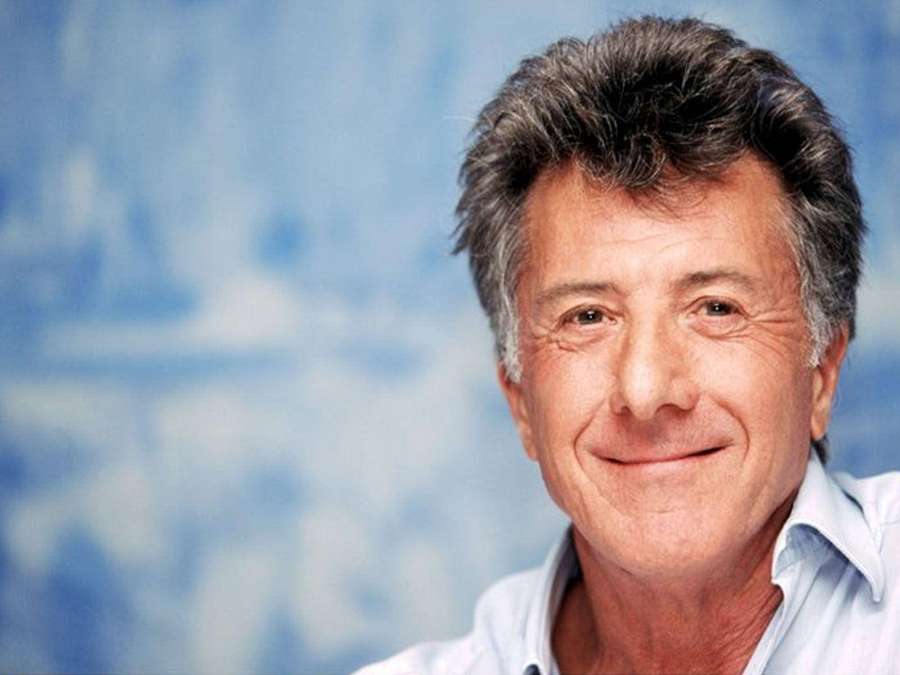 A smiling man with graying hair wearing a light blue shirt. — Dustin Hoffman Wallpaper