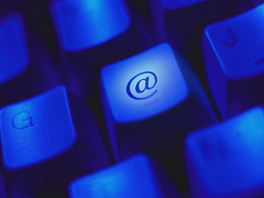 Blau beleuchtete Tastatur, die das At-Zeichen für E-Mail oder Online-Nutzung hervorhebt. — E mail Wallpaper